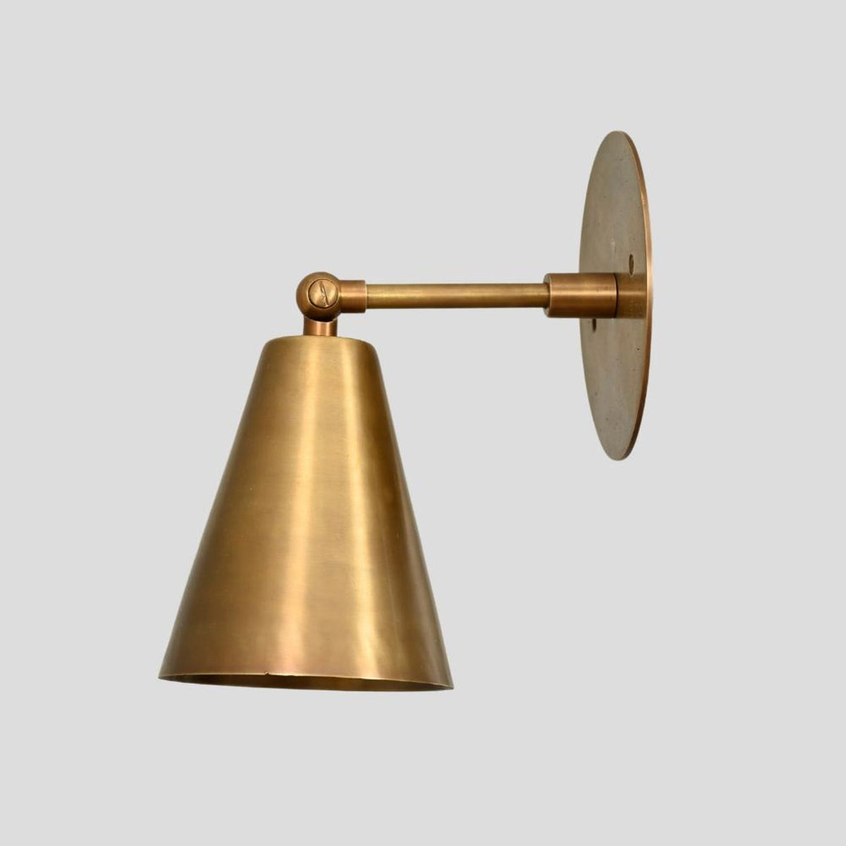 Brass wall sconce with cone shade, adjustable arm design, modern industrial wall light front view.