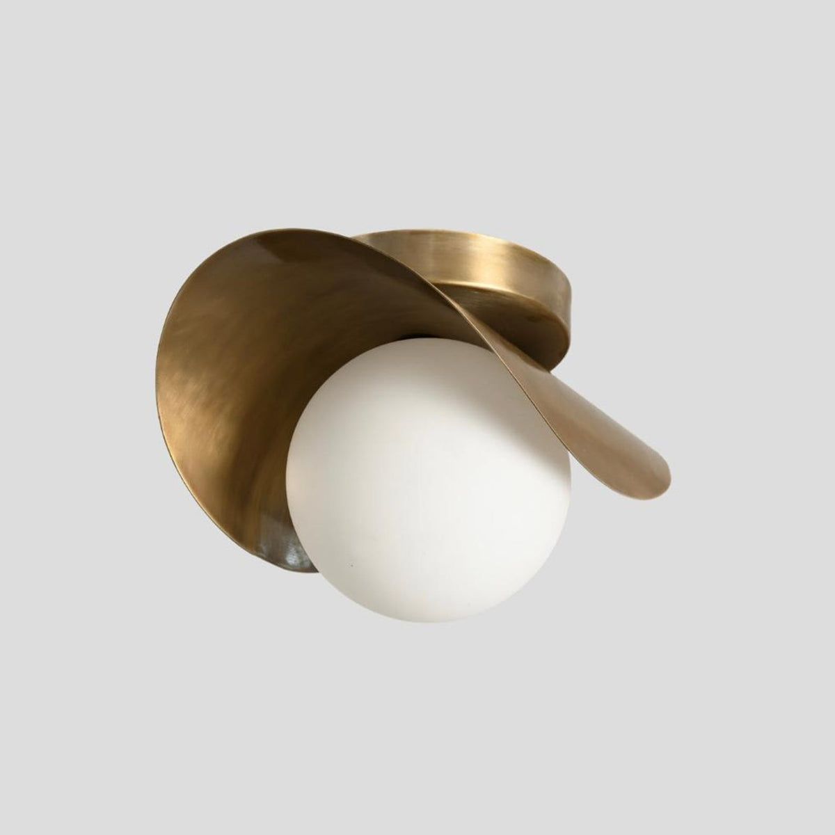 Brass wave flush mount ceiling light with artistic curved brass form and opal glass globe