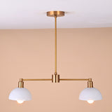 Illuminated brass and white dome pendant light casting warm downward glow