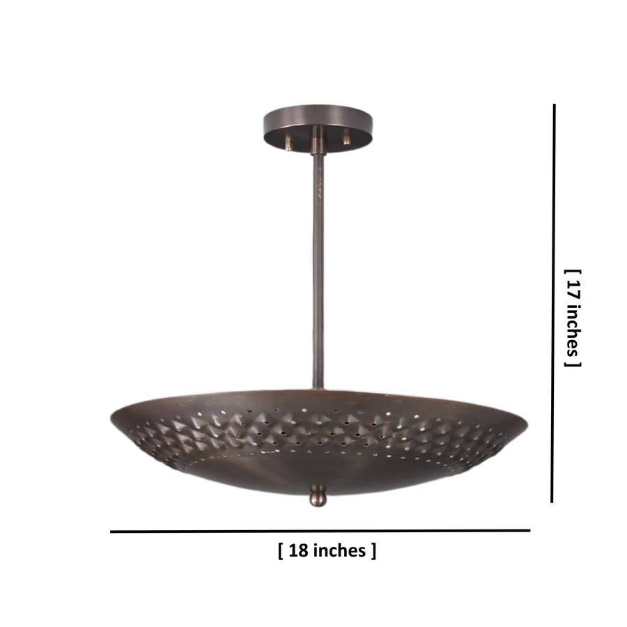 Brushed brass disc ceiling light illuminated with perforated design pattern
