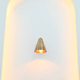 Bruges brass cone sconce styled as a compact bedside wall light in a modern bedroom