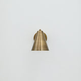 Solid brass Bruges wall sconce with minimalist cone shade and warm patina finish
