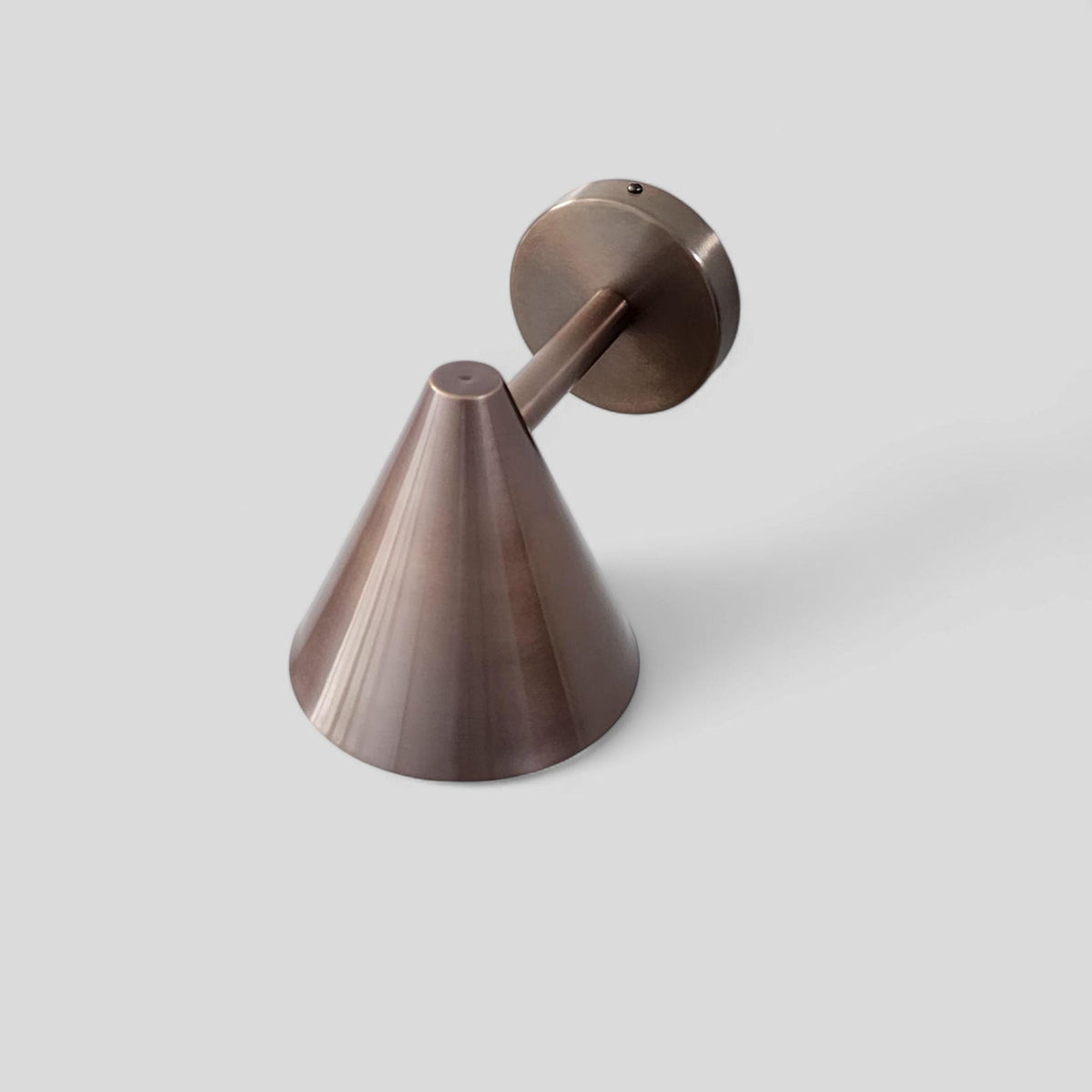 Top view of brushed antique brass wall sconce featuring elegant cone shape and artisanal brass detailing.