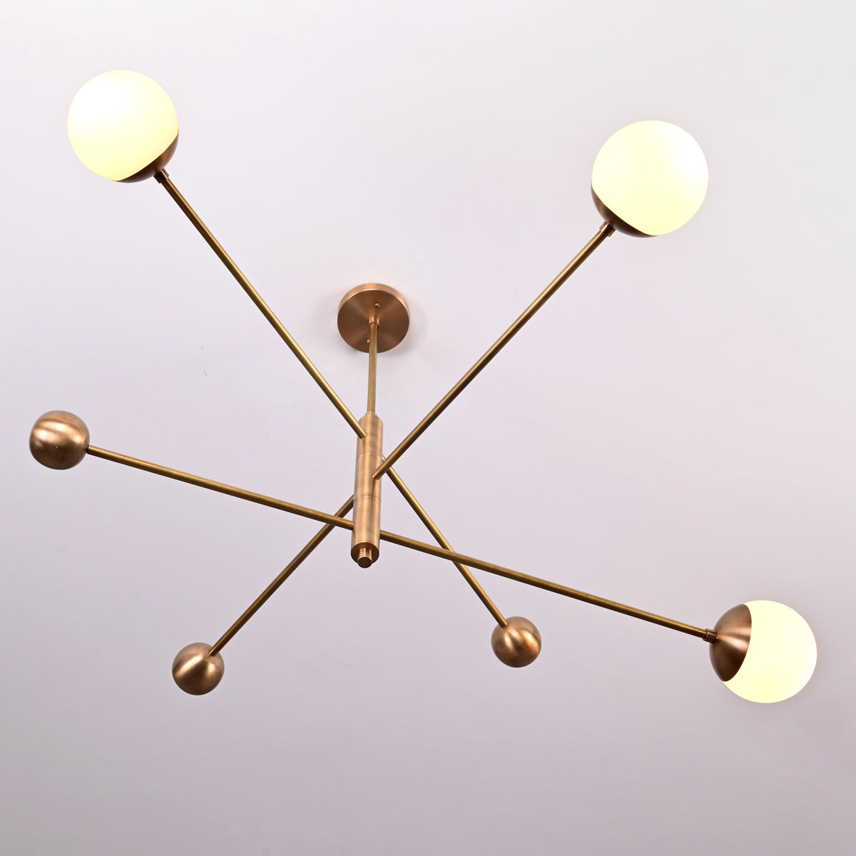 Mid-century style brushed brass chandelier with floating globe arrangement, handcrafted modern ceiling light.