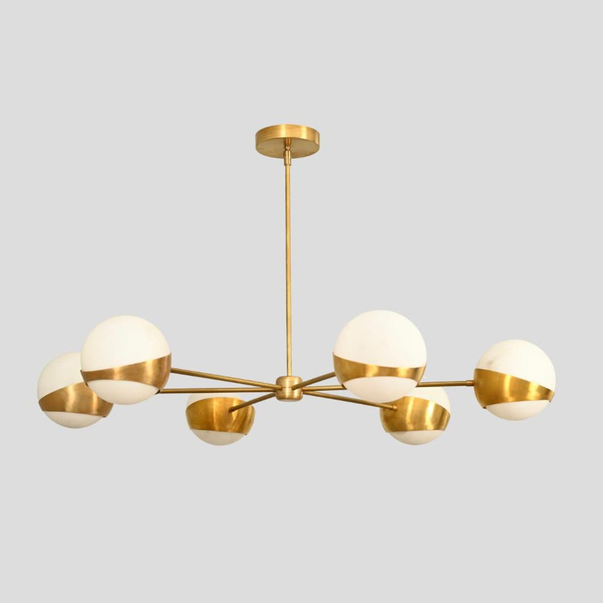 Brushed brass six-light chandelier with globe shades, elegant handmade ceiling fixture.