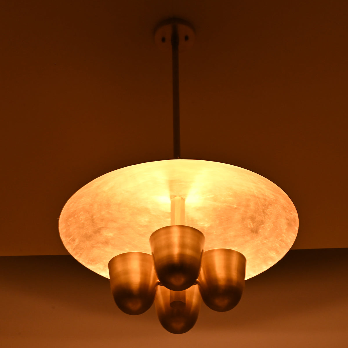 Handmade brass disc chandelier casting indirect ambient light, four bowl design ideal for dining rooms and living spaces