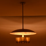 Moody lighting effect from brushed brass disc chandelier with four bowl shades, luxury handcrafted ceiling light by Brass Leaf Studio
