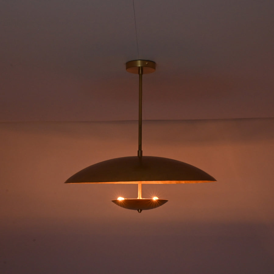 Front view of brushed brass disc pendant light with layered bowl shades and minimalist profile.