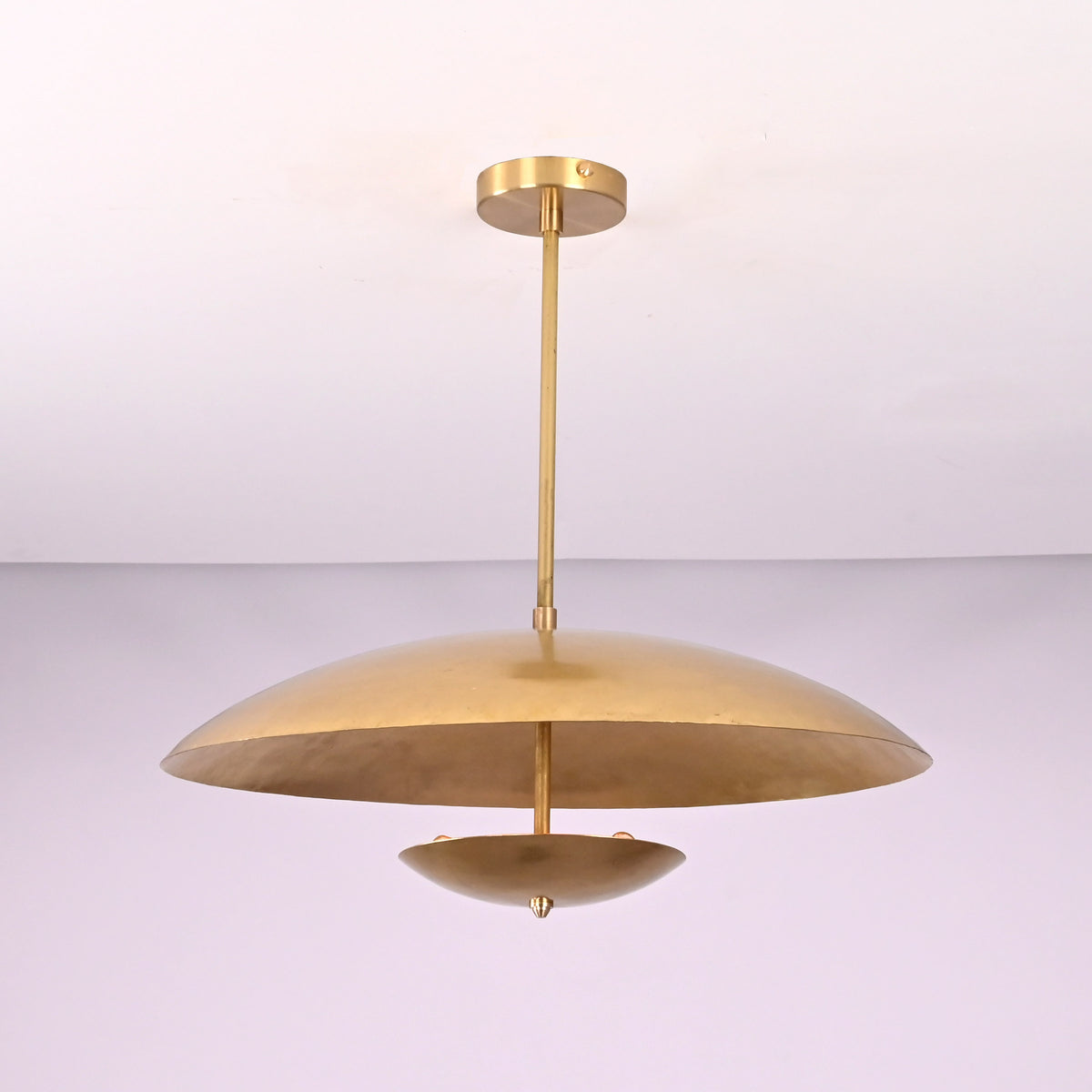 Side profile of modern brushed brass pendant light with wide bowl shade and clean silhouette.