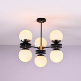 Brushed brass chandelier with six opal glass globes providing warm ambient lighting