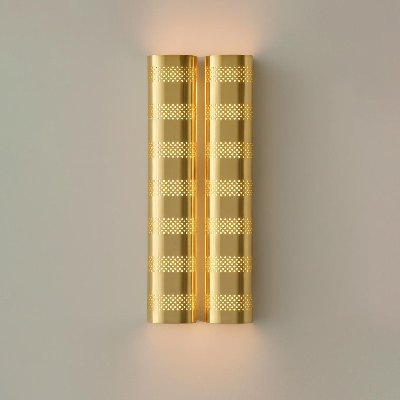 Brushed brass perforated wall sconce with warm ambient glow, modern industrial brass wall light by Brass Leaf Studio