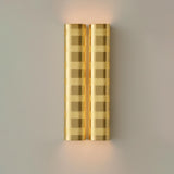 Brushed brass perforated wall sconce with warm ambient glow, modern industrial brass wall light by Brass Leaf Studio