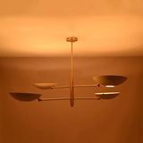 Brushed brass saucer chandelier shown from angled view with slim rods, central stem, and sculptural bowl shades