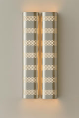 Brushed chrome finish perforated brass wall sconce providing soft indirect lighting in a modern interior
