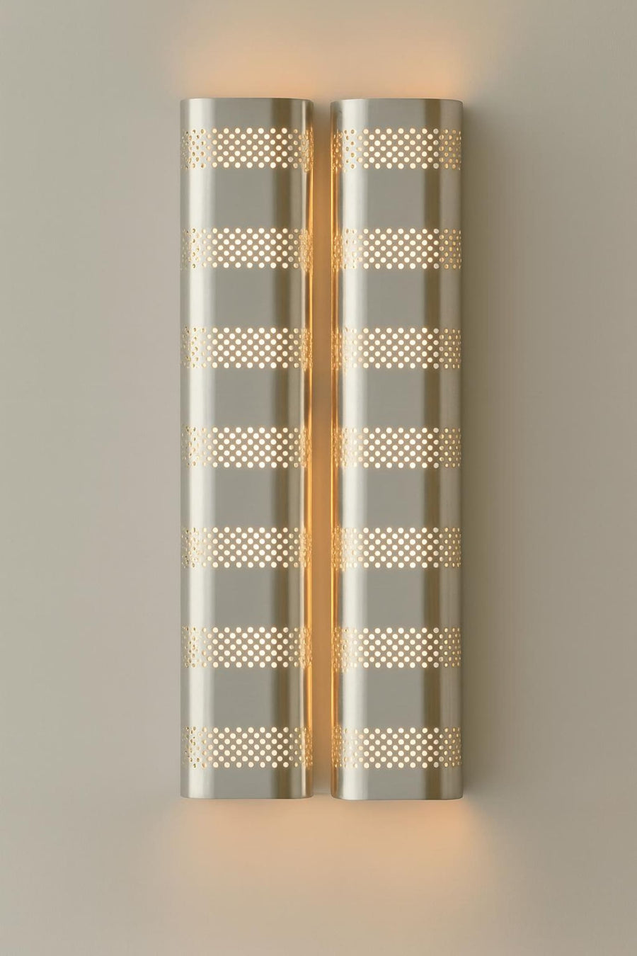 Brushed brass perforated wall sconce with warm ambient glow, modern industrial brass wall light by Brass Leaf Studio