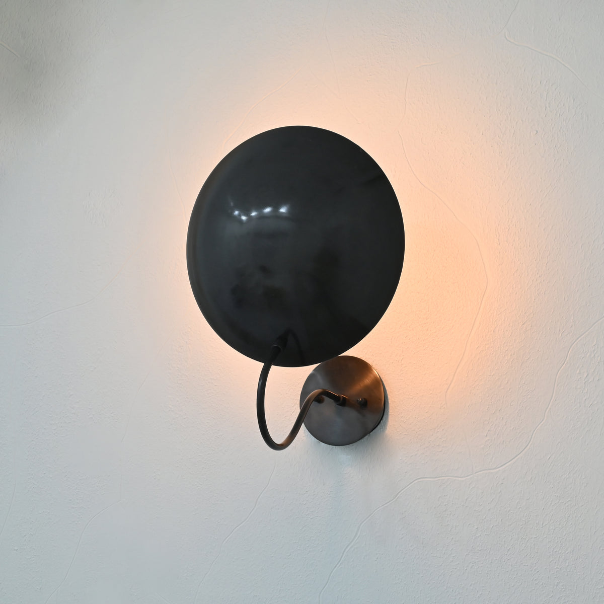 Brussels blackened brass wall sconce styled as elegant bedside lighting in a modern bedroom