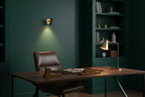 Casablanca brass wall sconce shown illuminated with soft warm light projected downward on the wall
