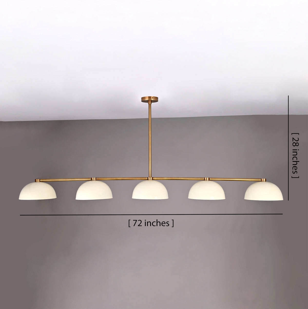 Front view of 72-inch wide, 28-inch tall linear brass chandelier with dome shades shown against a gray wall