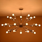 Evening view of illuminated chrome Sputnik chandelier with glowing bulbs and polished metallic finish
