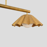 Close-up of handcrafted brass chandelier with ruffle-edged shade and globe bulb, showcasing artisan detail.
