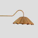 Close-up view of pleated brass bowl shade on chandelier, showcasing handmade detailing and elegant brass texture.