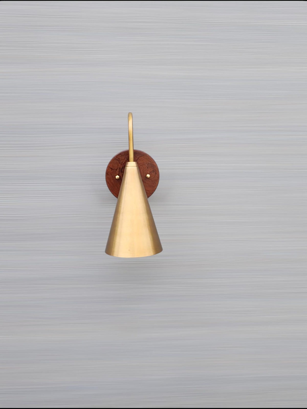 Mounted view of cone brass and wood wall light on neutral background showing refined craftsmanship and smooth brass patina.