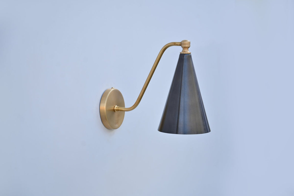 Contemporary blackened brass cone sconce with elegant fixed arm and satin brass mount, perfect for accent lighting.