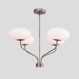 Contemporary brass chandelier with four frosted bowl shades and curved brass arms, perfect for dining or living spaces.