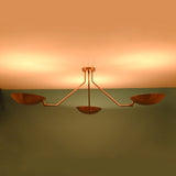 Copper 3-light flushmount chandelier with bowl shades glowing against a warm-toned ceiling.