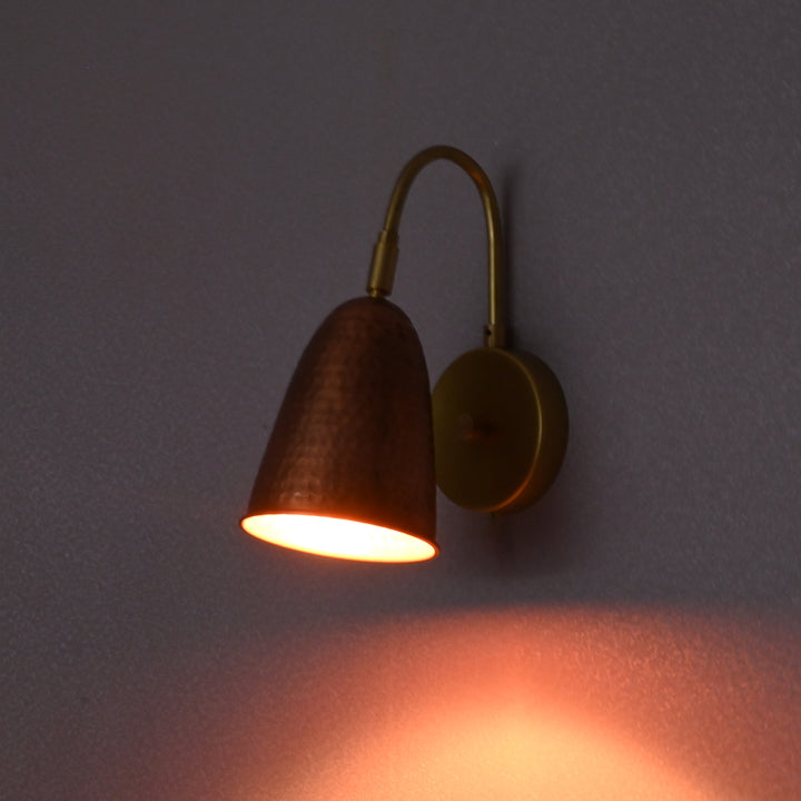 Copper hammered wall sconce glowing light – ambient brass wall lamp for warm and cozy interiors