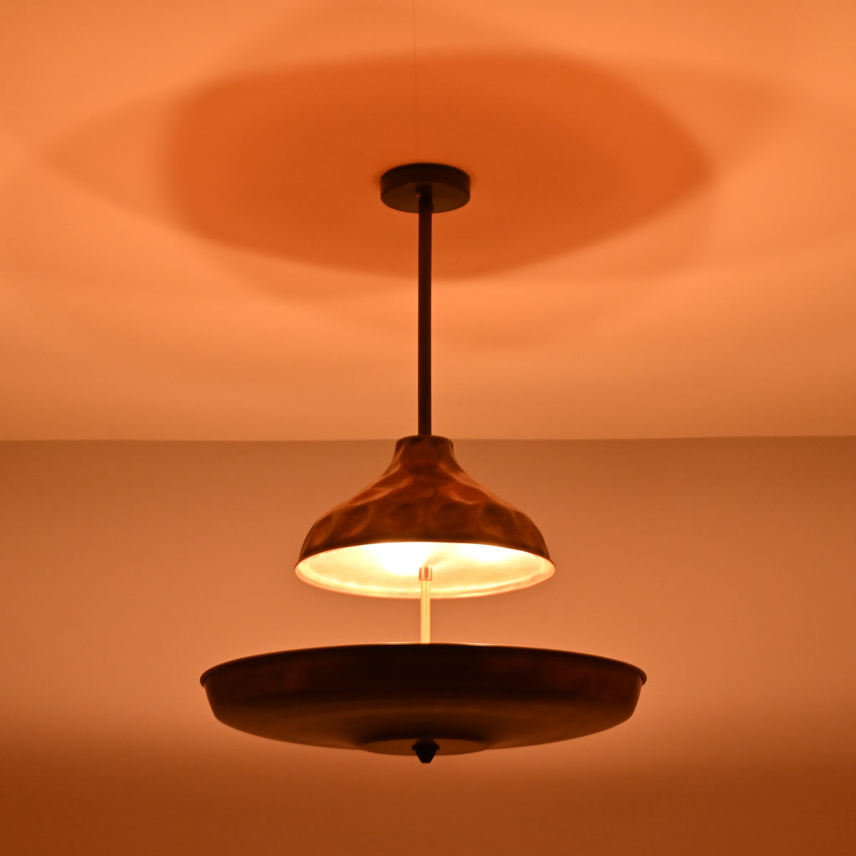 Copper chandelier creating a soft halo lighting effect on the ceiling with indirect illumination