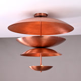Flush mount chandelier with exposed bulbs nestled between sculpted copper tiers