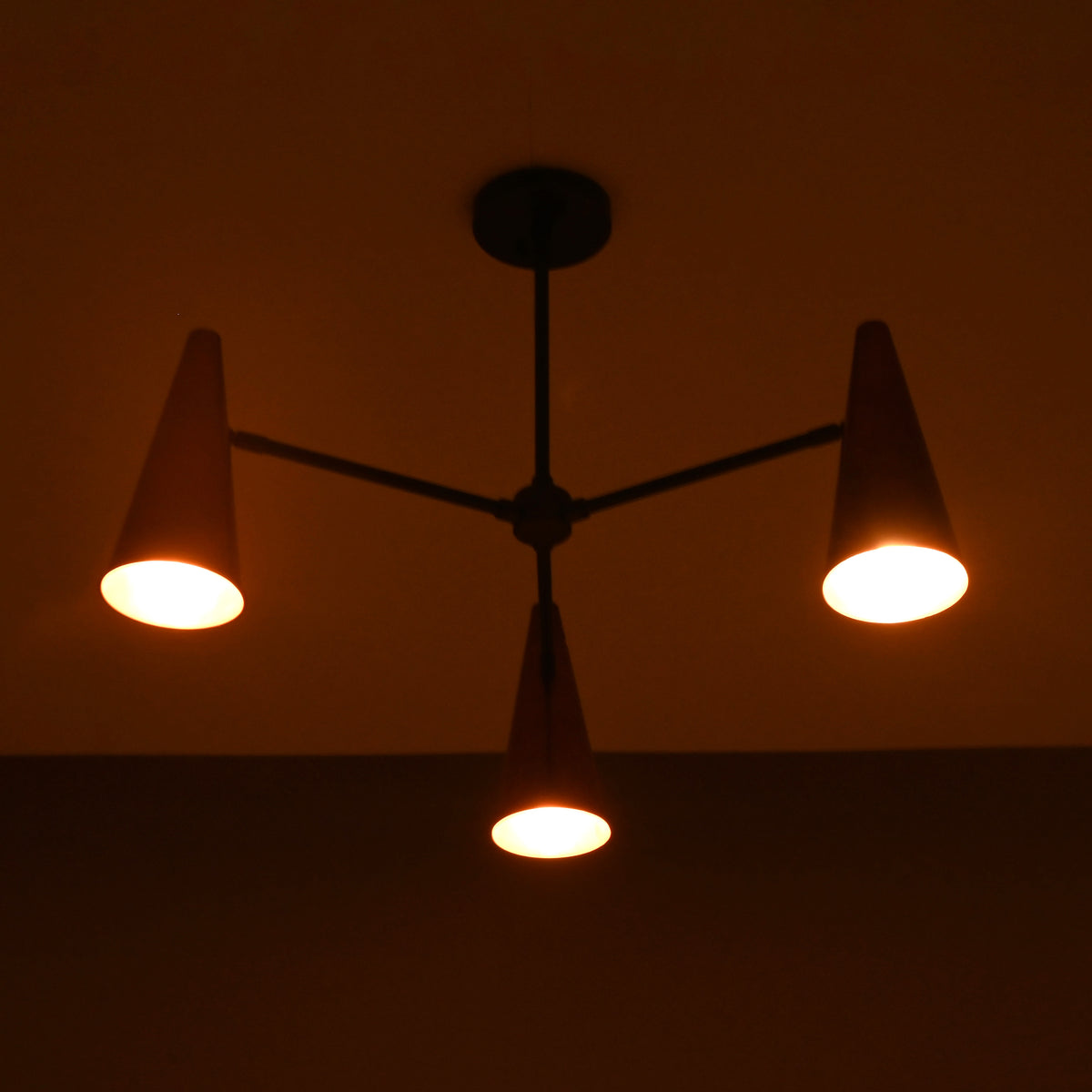 Close-up of glowing copper cone shade highlighting warm light diffusion and brass craftsmanship