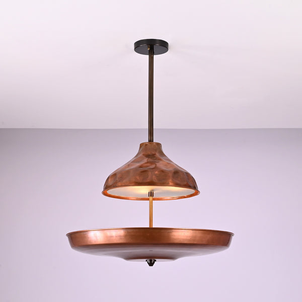 Modern copper disc chandelier with warm indirect lighting and sculptural bowl shade, handcrafted from solid brass