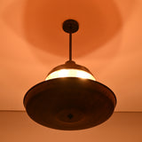 Moody lighting view of copper disc chandelier with warm glow, ideal for modern and industrial interiors