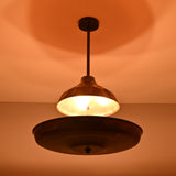 Copper disc chandelier casting warm ambient indirect lighting, creating a soft glow across the ceiling