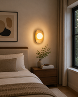 Crescent brass wall sconce with glowing opal glass globe for modern accent lighting
