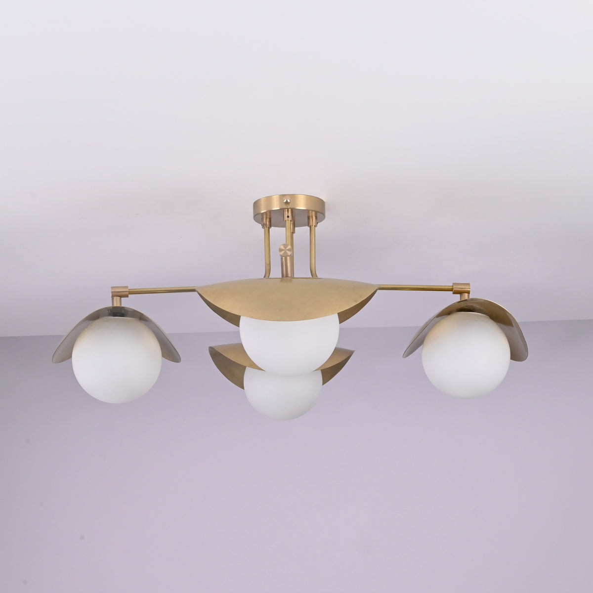 Curva 4-light brushed brass flush mount ceiling light with curved bowl shades and opal globe diffusers, handcrafted by Brass Leaf Studio.