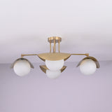 Curva 4-light brushed brass flush mount ceiling light with curved bowl shades and opal globe diffusers, handcrafted by Brass Leaf Studio.