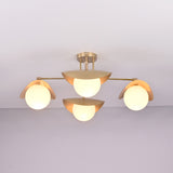 Lit front view of Curva brass flush mount featuring warm ambient glow, curved brass shades, and minimalist globe design.