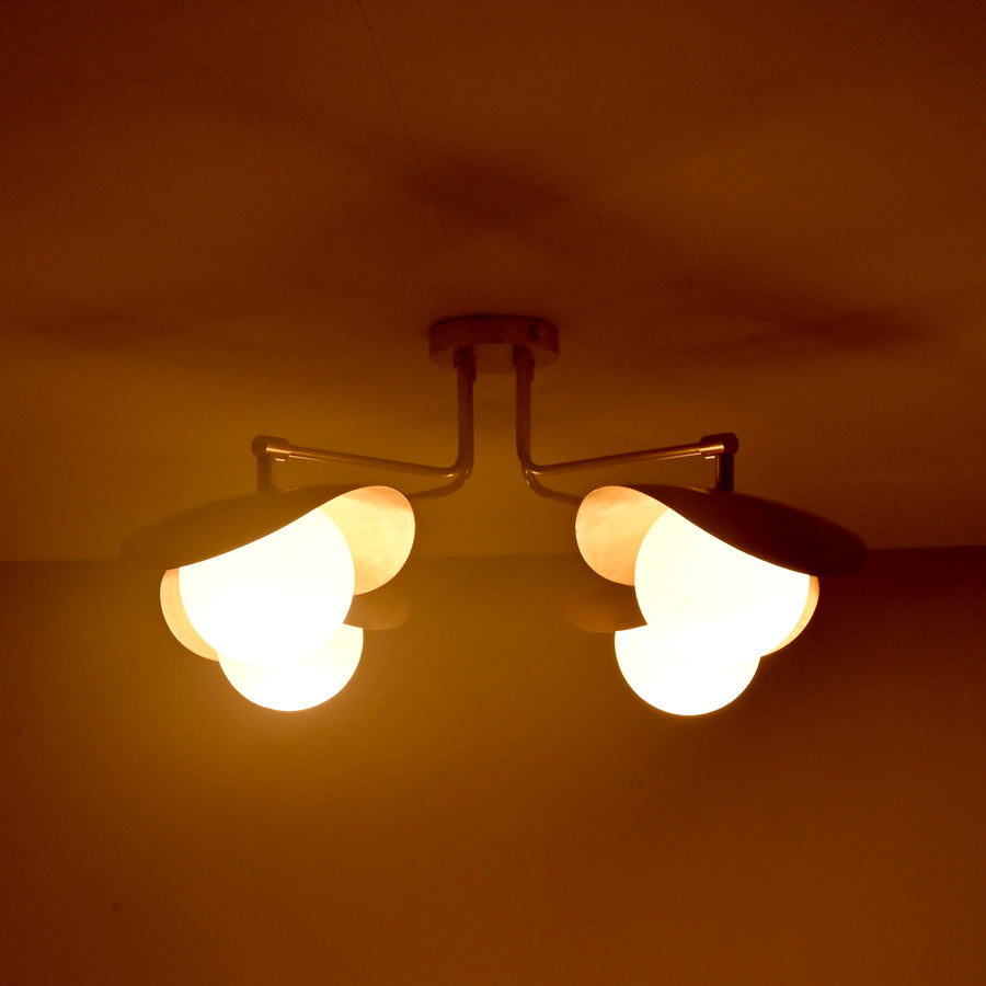 Angled view of Curva curved shade brass ceiling light highlighting sculpted forms and refined brushed brass finish.