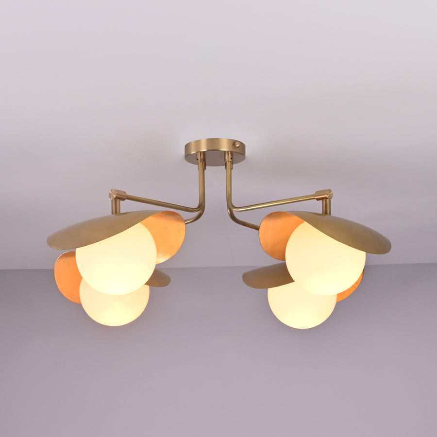 Angled view of Curva curved shade brass ceiling light highlighting sculpted forms and refined brushed brass finish.
