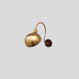 Side view of brass dome shade wall sconce with wooden base plate