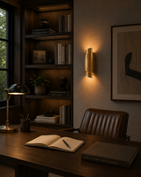 Curved brass wall sconce shown from side angle with layered vertical ribbon shade design