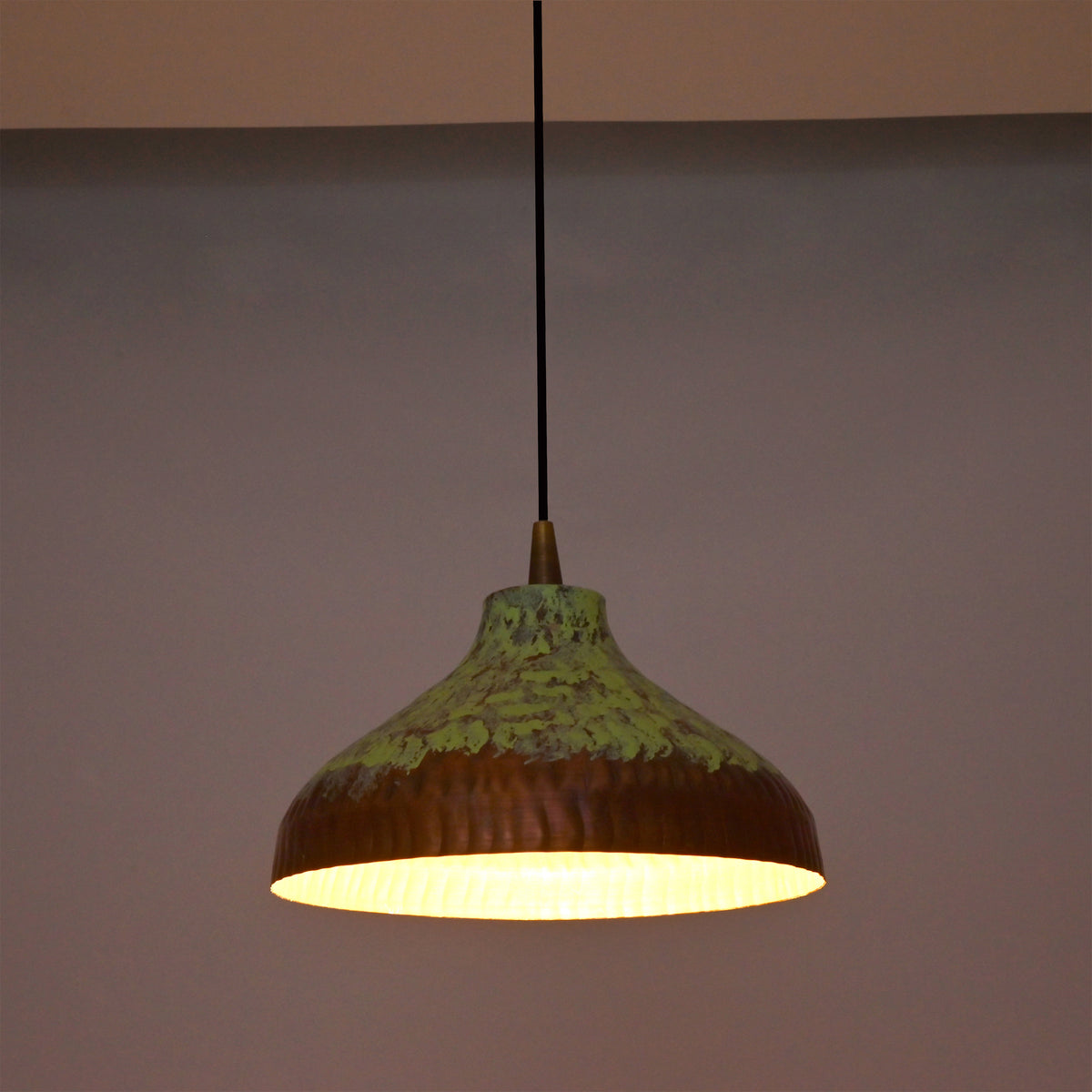 Custom copper pendant light with black cord, copper canopy, and green patina dome shade for modern rustic interiors