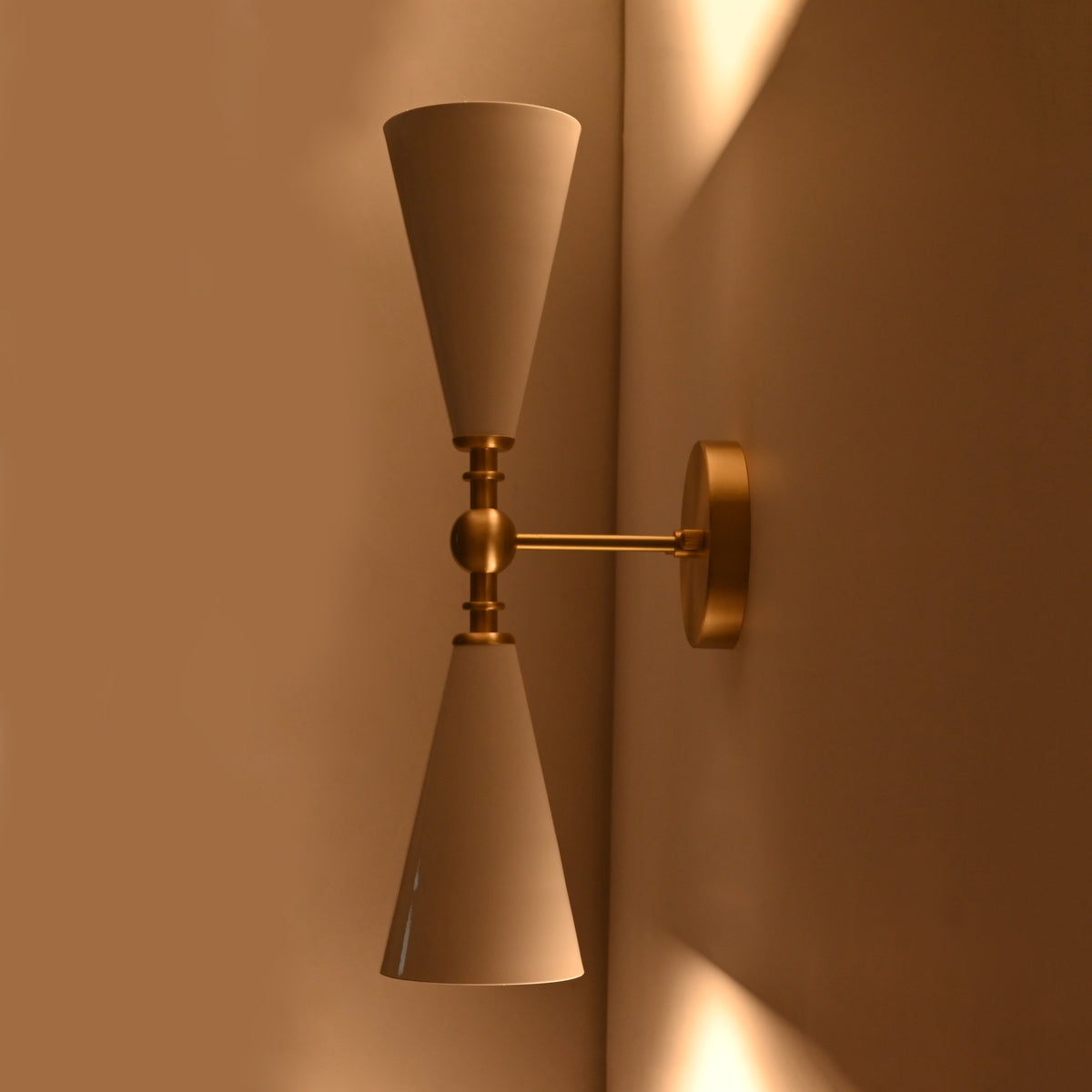 Customizable double cone wall sconce with enamel painted shades and brushed brass finish details
