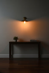 Custom full brass wall sconce with scalloped shade, Edison-style bulb, and warm downward ambient glow