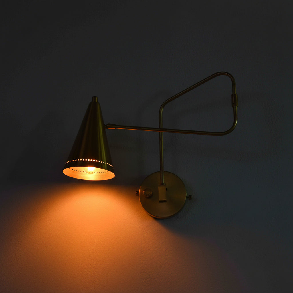 Custom raw brass wall sconce with movable arm, cone shade, and warm glow for bedroom or hallway lighting