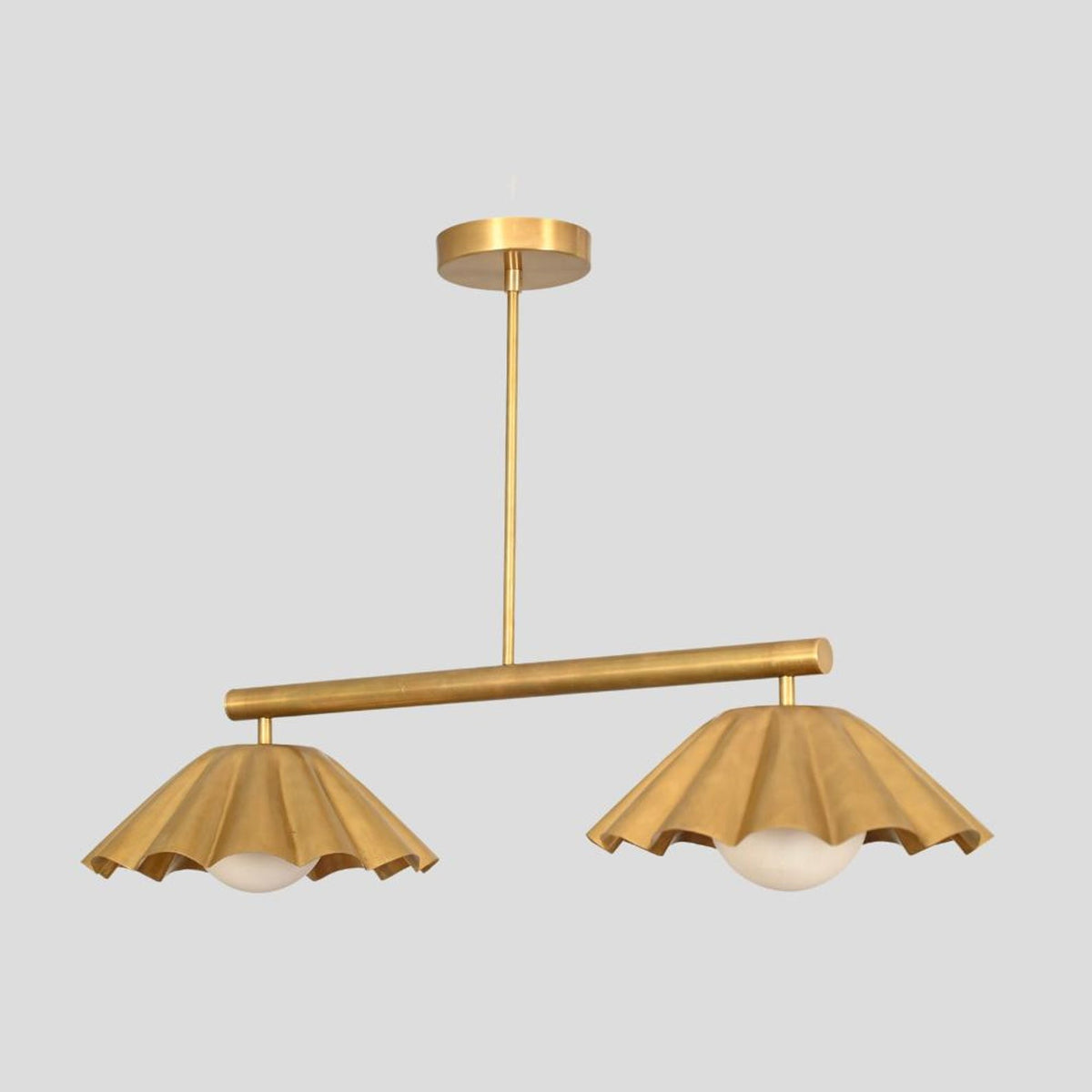 Customizable brass pendant chandelier with ruffled cone shades and round globe lights, minimalist yet artistic design.