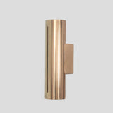 Modern tubular brass wall light with minimalist slit detail, perfect for living rooms, hallways, and boutique interiors.